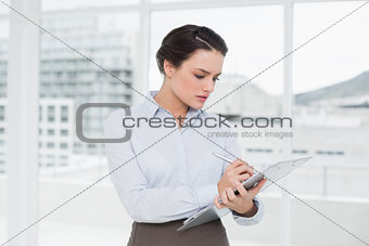 Elegant businesswoman with clipboard in office