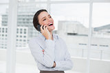 Cheerful businesswoman using cellphone in office