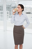 Elegant businesswoman drinking coffee in office