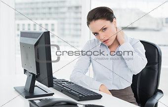 Businesswoman with neck pain sitting at office