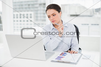 Businesswoman with graphs and laptop in office