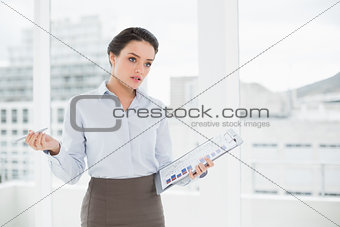 Elegant businesswoman with graphs in office
