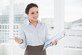 Smiling businesswoman with graphs in office
