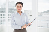 Elegant businesswoman with clipboard in office