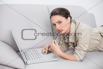 Beautiful young woman using laptop on sofa at home