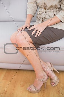 Low section of an elegant woman sitting on sofa