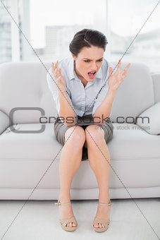 Elegant woman shouting in anger at home