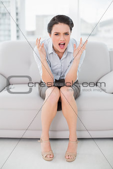 Elegant young woman shouting in anger at home