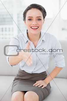Smiling well dressed woman offering a handshake