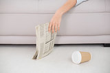 Asleep woman holding newspaper on sofa