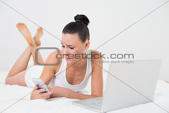 Casual young woman with cellphone and laptop