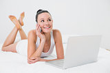 Smiling casual woman using cellphone in bed