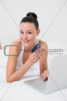 Casual woman doing online shopping in bed