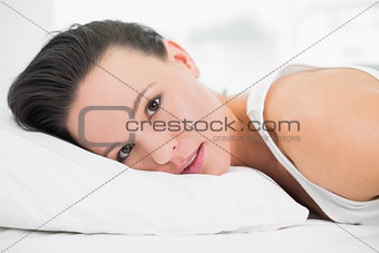 Pretty young woman lying in bed