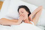 Close up of a beautiful woman yawning in bed