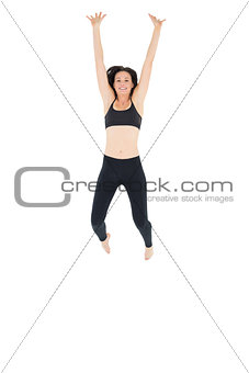 Sporty young woman jumping over white background