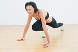 Determined woman doing push ups in fitness studio