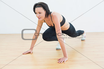 Determined woman doing push ups in fitness studio