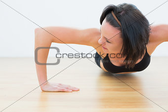 Determined sporty woman doing push ups in fitness studio