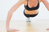 Mid section of a sporty woman doing push ups