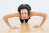 Determined beautiful woman doing push ups in fitness studio