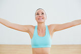 Smiling toned young woman with arms outstretched