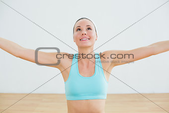 Smiling toned young woman with arms outstretched