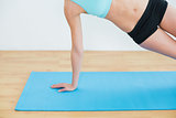 Slim woman doing the side plank yoga pose