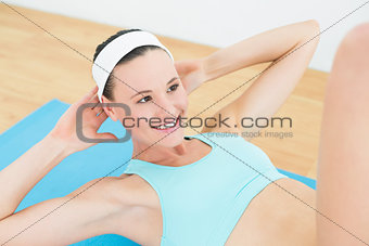 Smiling woman doing sit ups on exercise mat