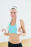 Slender woman with towel around neck in fitness studio