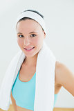 Slender woman with towel around neck in fitness studio