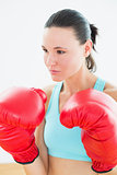 Close up of a beautiful young woman in red boxing gloves