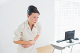 Businesswoman with stomach pain in office
