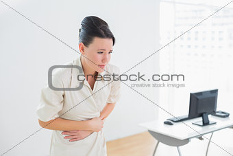 Businesswoman with stomach pain in office