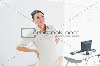 Businesswoman suffering from back ache in office