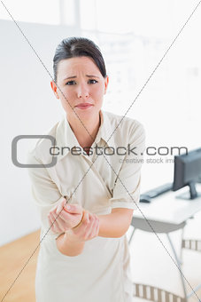 Businesswoman suffering from wrist pain in office