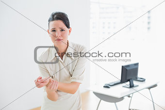 Businesswoman suffering from wrist pain in office