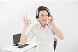 Businesswoman wearing headset while gesturing ok sign