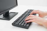 Hands typing on keyboard in an office