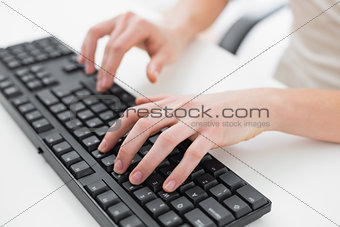 Midsection of a businesswoman typing on keyboard