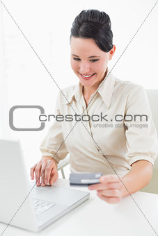 Smiling young businesswoman doing online shopping