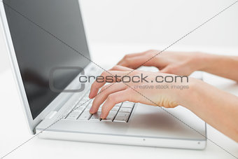 Close up of hands typing on laptop keyboard