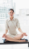 Smart businesswoman sitting in lotus position at office