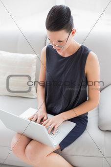 Beautiful well dressed young woman using laptop