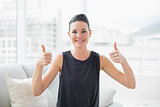 Smiling well dressed woman gesturing thumbs up