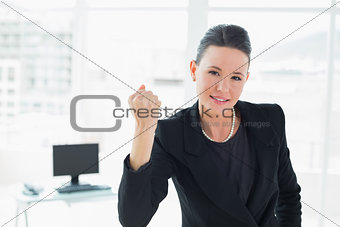 Elegant businesswoman clenching fist in office