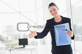 Elegant businesswoman offering a handshake in office
