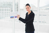 Elegant young businesswoman with graphs in office