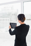 Rear view of businesswoman with tablet PC in office