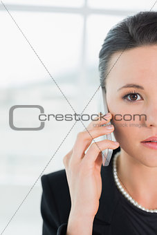 Close up of a serious elegant businesswoman using cellphone